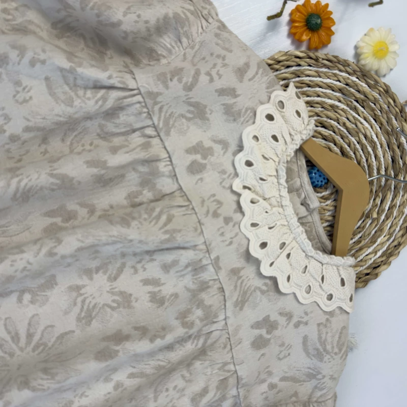 نمای نزدیک از پارچه طرح‌دار و آستین پفی شومیز دخترانه شیک.