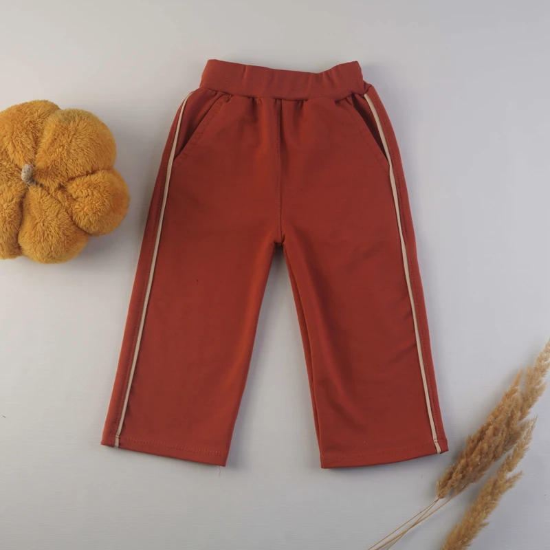 شلوار قرمز کمر کشی پسرانه با نوار سفید بغل ست شده با بلوز دورس