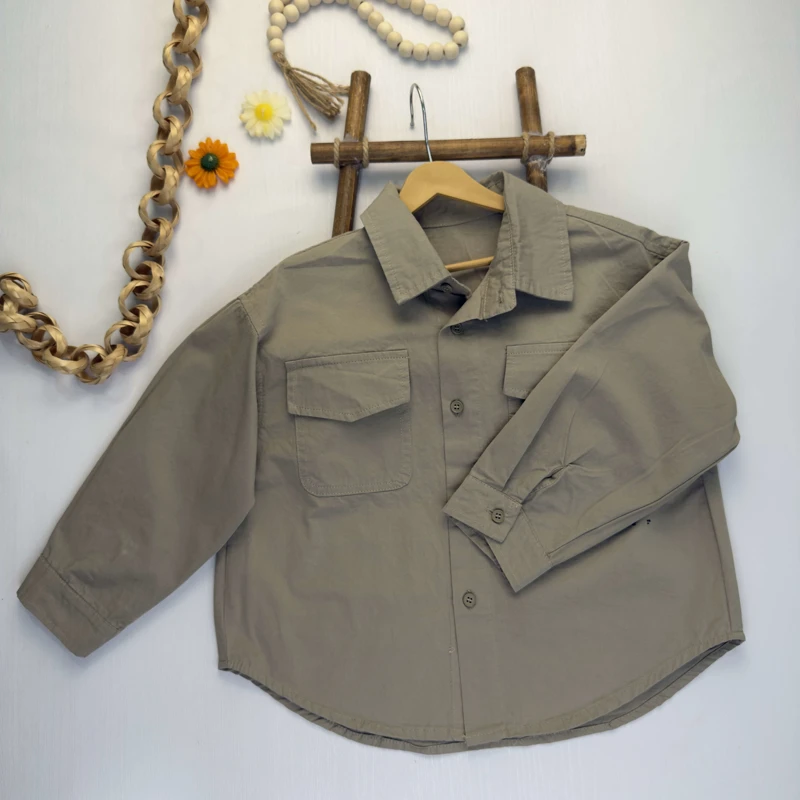 نمای نزدیک جیب‌ها و چاپ متن typewriter 1978 روی پیراهن خاکی