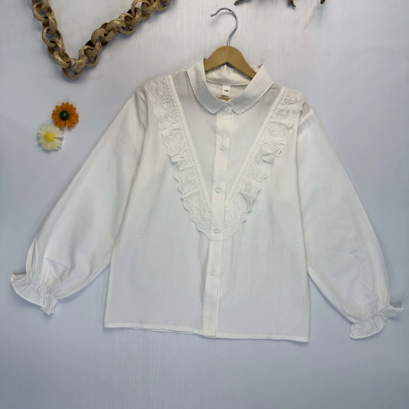 شومیز دخترانه سفید مجلسی با تزئینات توری و یقه برگردان روی رخت آویز