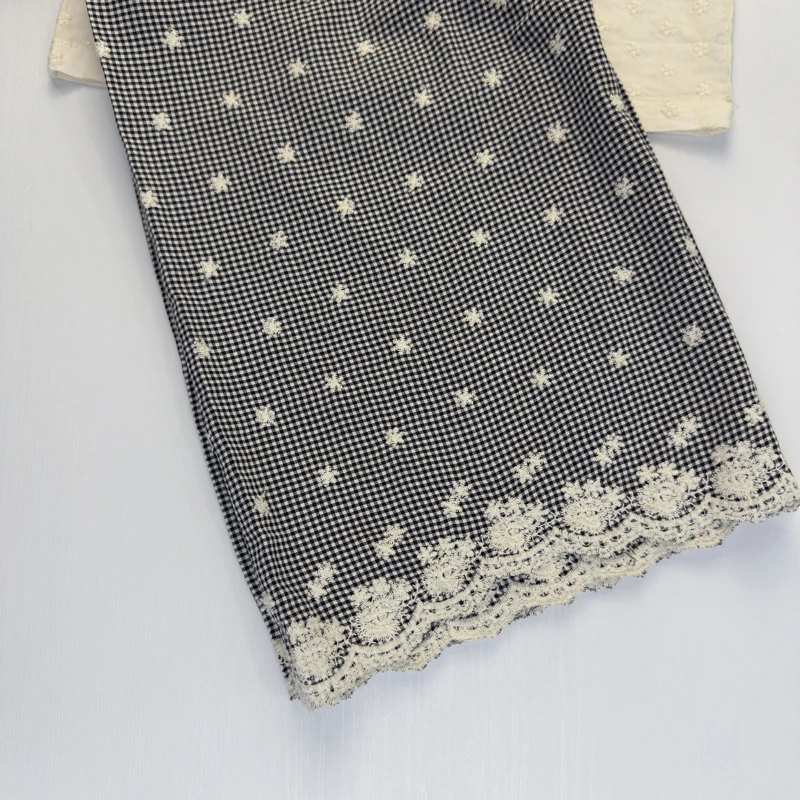 شلوار بچگانه چهارخانه با طرح گل‌های ریز و لبه دوزی گیپور سفید.