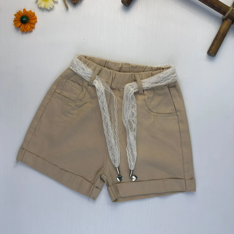 شلوارک کتان دخترانه رنگ کرم با کمربند توری سفید و آویز قلب.