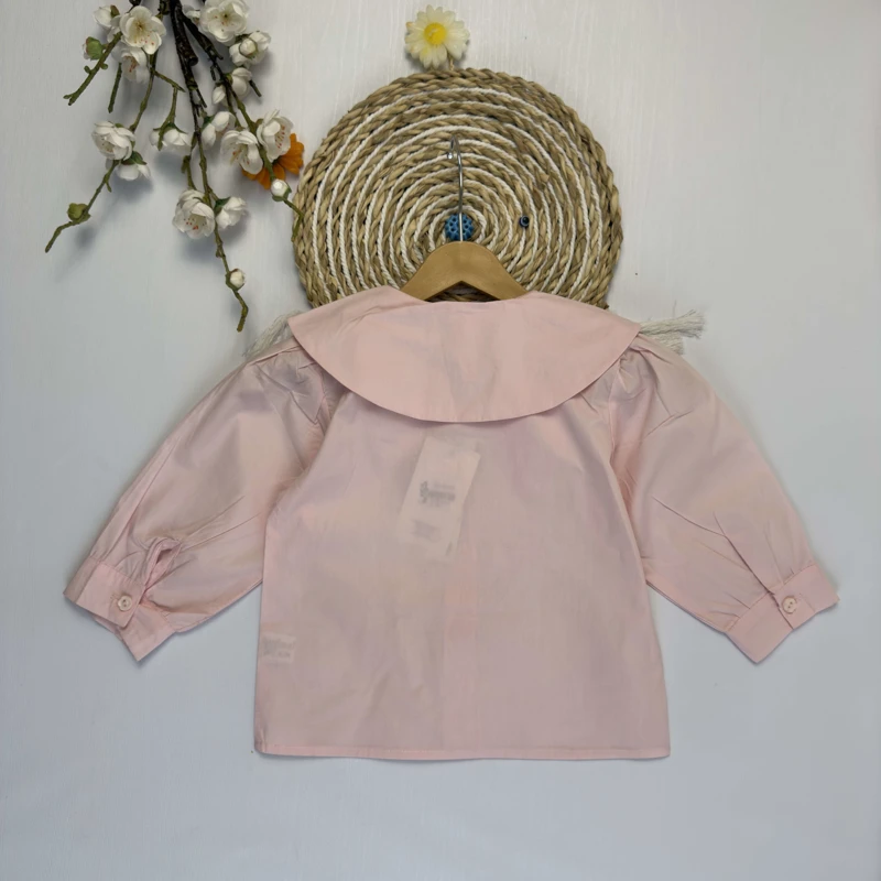 نمای نزدیک یقه شومیز دخترانه با تزئینات گل پارچه‌ای و خرگوش براق