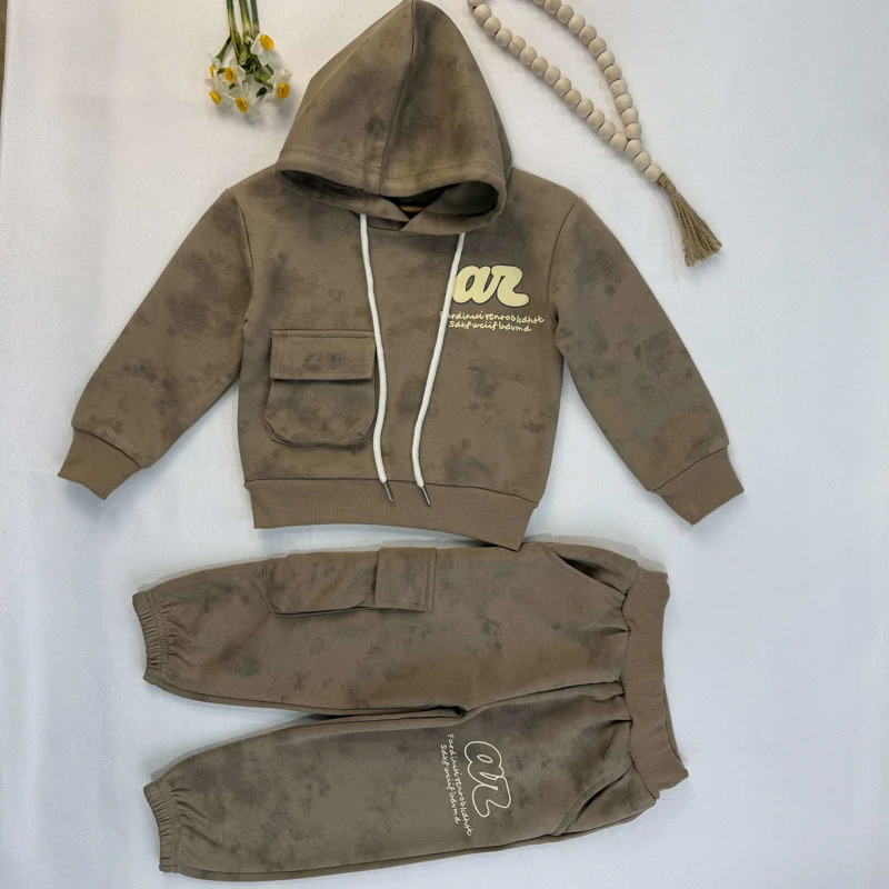 ست هودی و شلوار بچه‌گانه رنگ قهوه‌ای طرح ابروبادی روی زمین