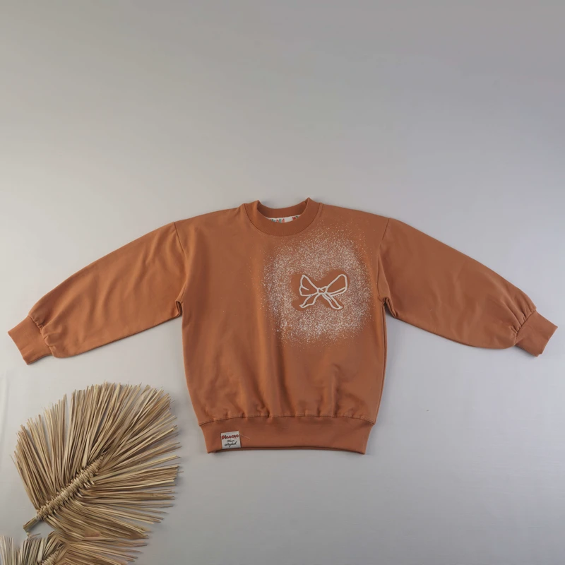 نمای نزدیک از چاپ پاپیون روی بلوز دورس دخترانه