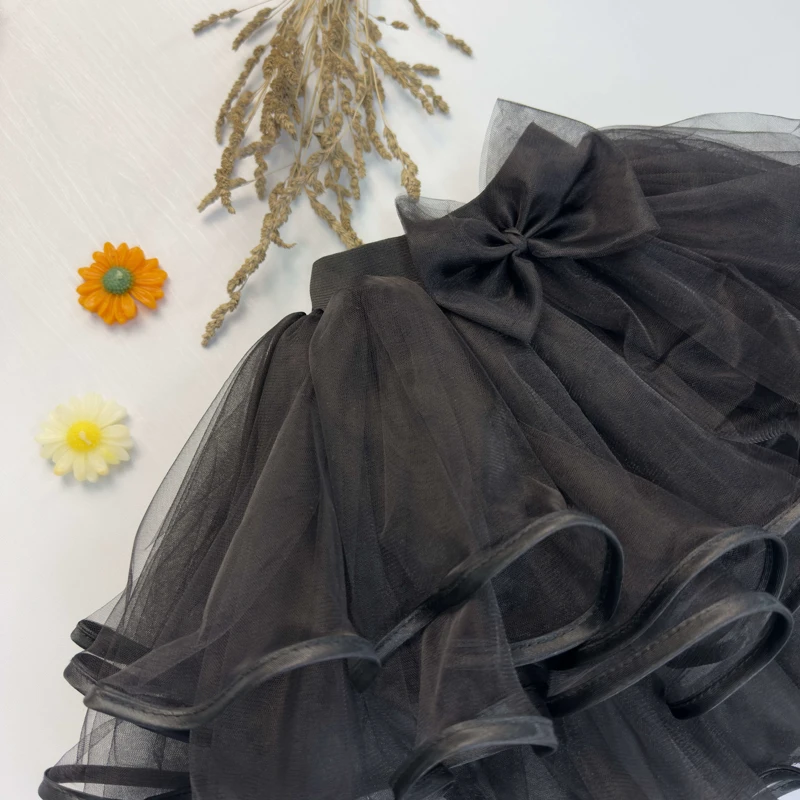 جزئیات کمر کشی و پاپیون تزئینی روی دامن توری کودک.