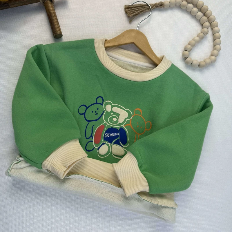 نمای نزدیک طرح چاپ شده سه خرس رنگی و خطی روی سینه لباس کودک.