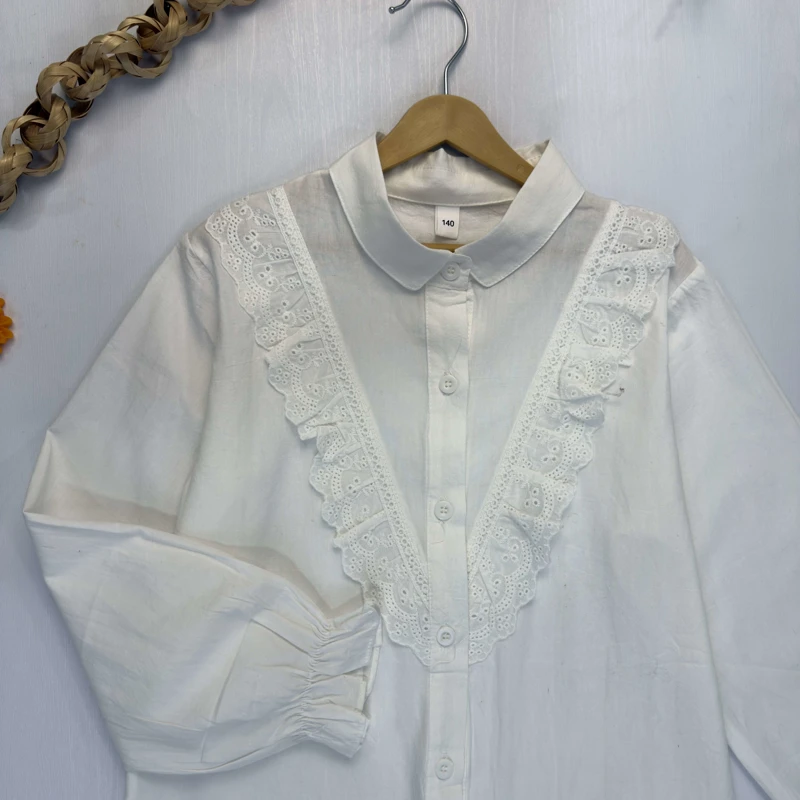 جزئیات دوخت توری و چین‌دار روی سینه بلوز سفید دخترانه