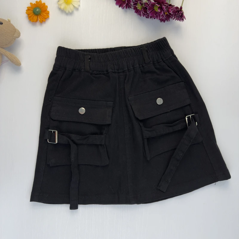 دامن کتان مشکی دخترانه مدل کارگو با بندهای سگک‌دار آویزان.