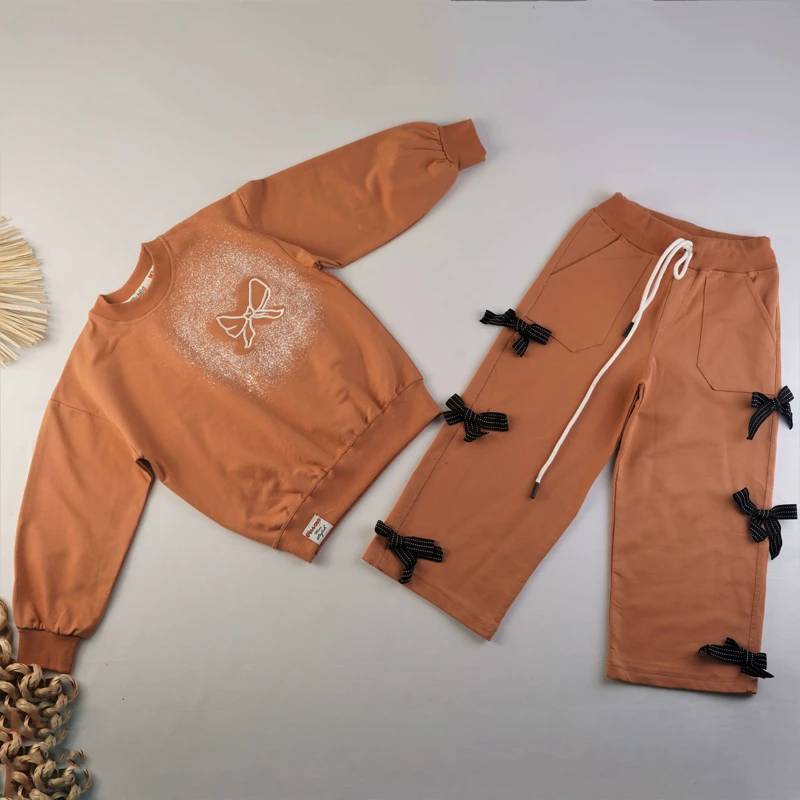 ست دورس و شلوار دخترانه نارنجی با تزئین پاپیون مشکی